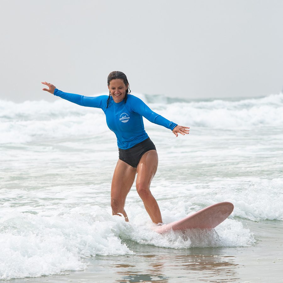 Woman surfing at Surf Getaways in Byron Bay, Australia 