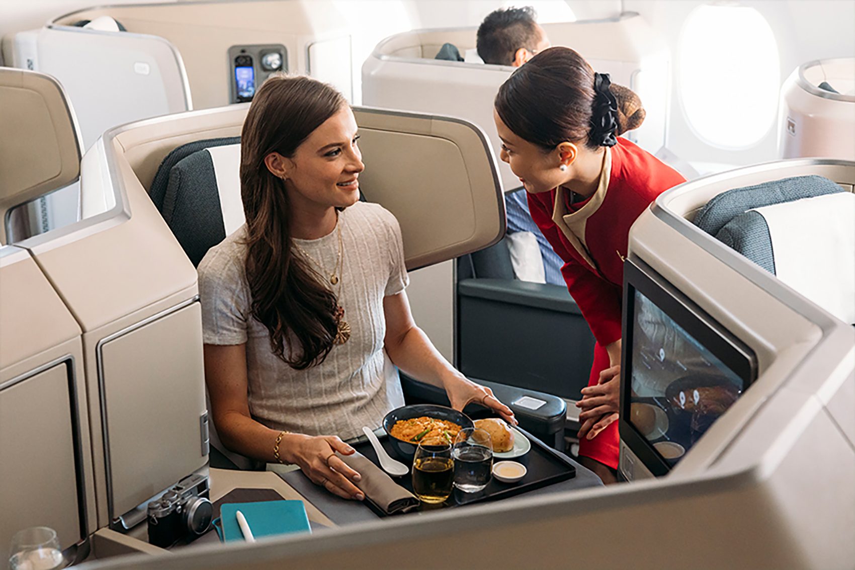 Cathay Pacific flight attendant serving passenger on flight