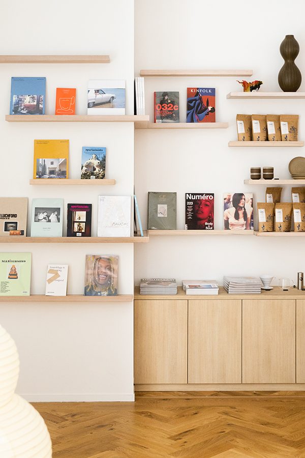 A curated selection of books and magazines  on floating wooden shelves inside Chinatown Country Club fashion concept store in Sydney CBD, Australia