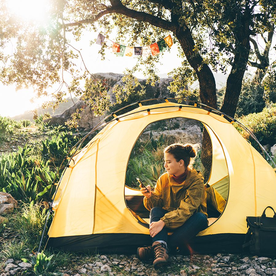 Woman in tent on phone. Credit: Getty Images