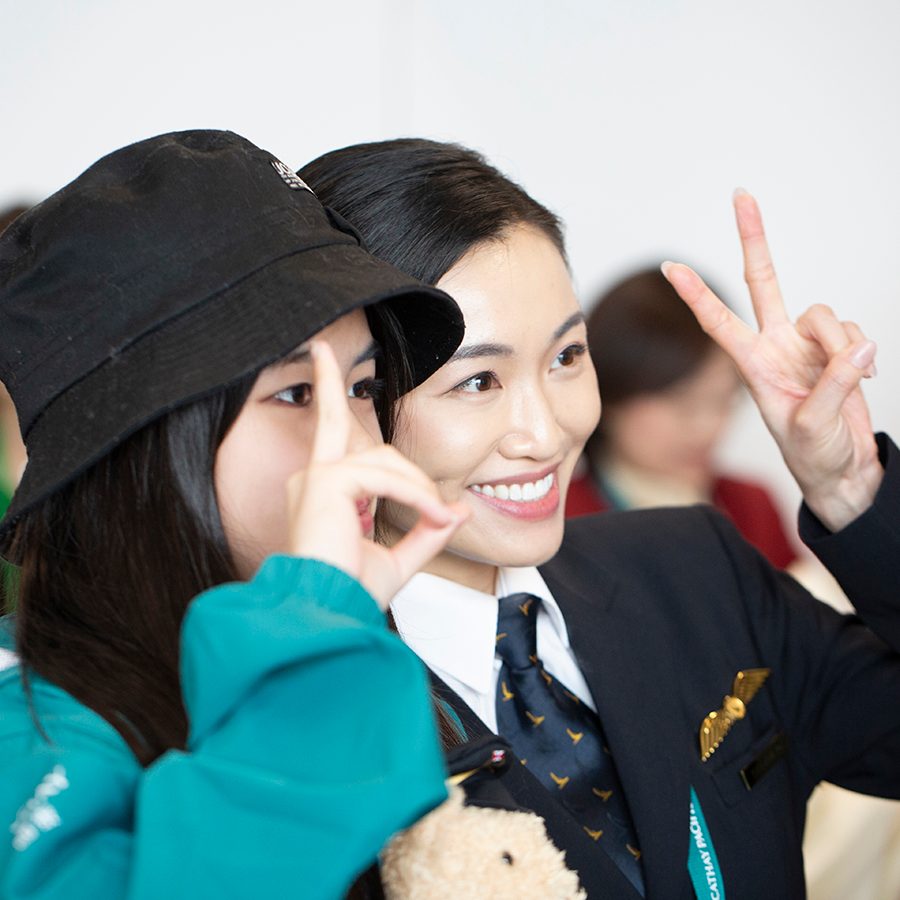 A Cathay Pacific team member poses with a passenger