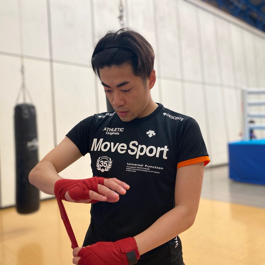 Ambrose Chan preparing his boxing wraps