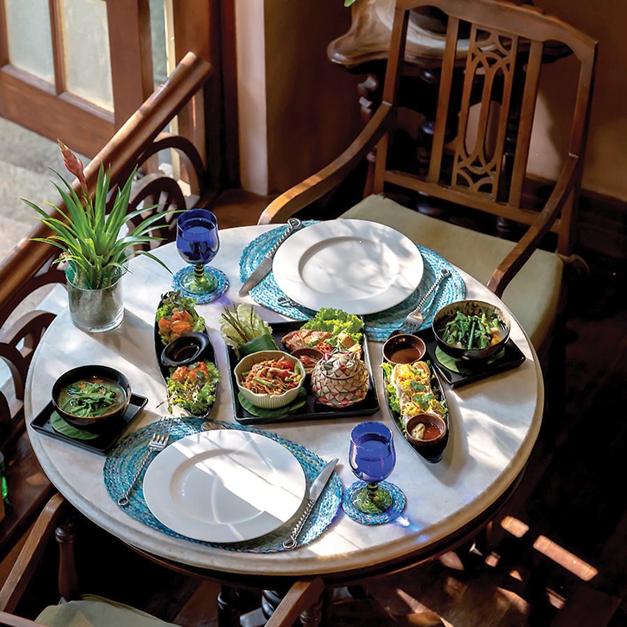 A table with plates and bowls of food on it