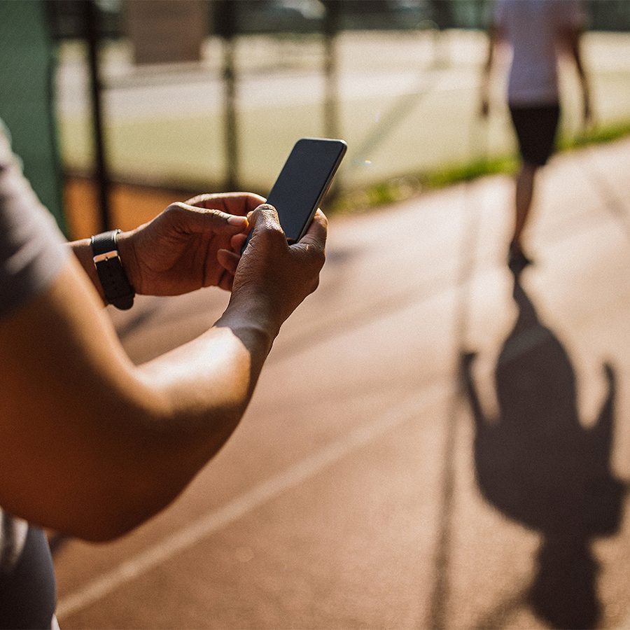 Warm sunlight shining on a person using a smartphone on a running track