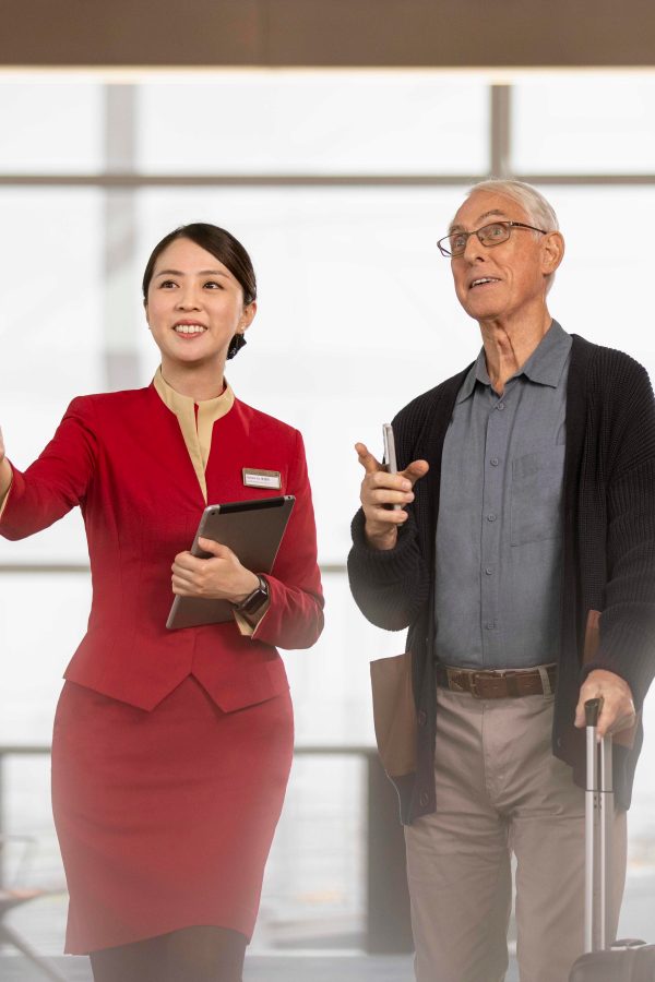 A Cathay Pacific's airport female ground staff providing assistance to a passenger at the airport
