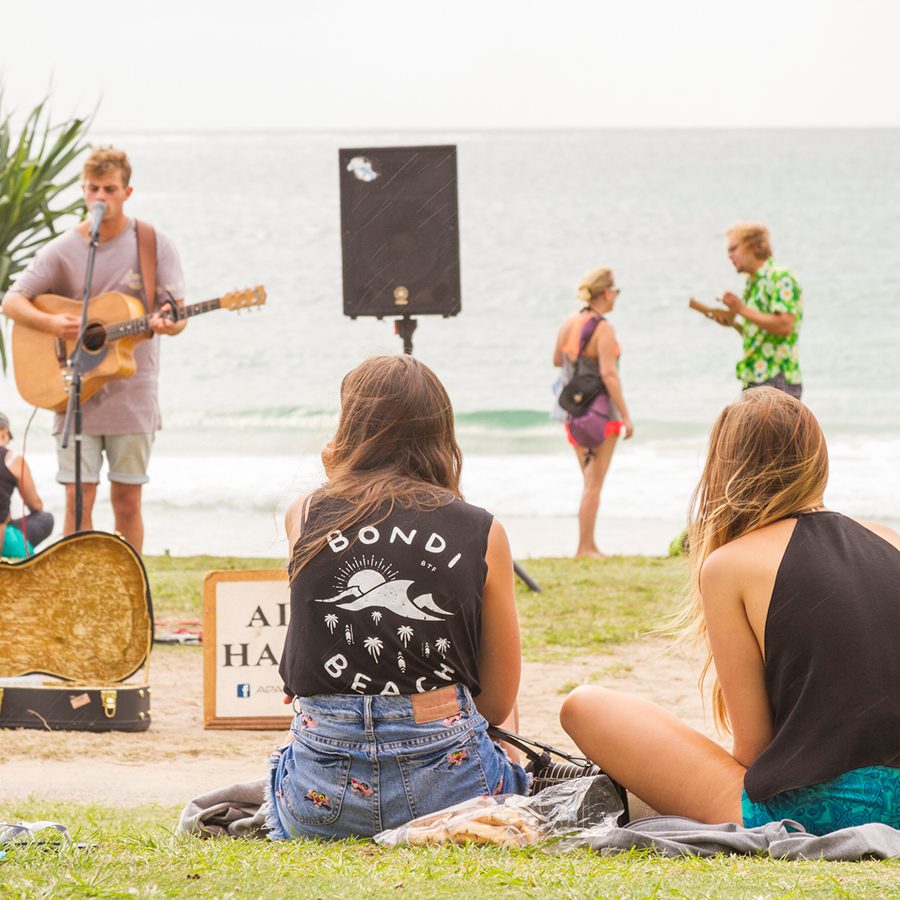 Women sat on Bondi Beach listening to music