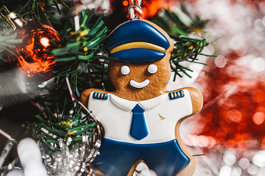 A close up of Cathay's DIY christmas gingerbread-themed ornament, featuring a gingerbread man wearing a Cathay Pacific pilot uniform hanging on a Christmas tree