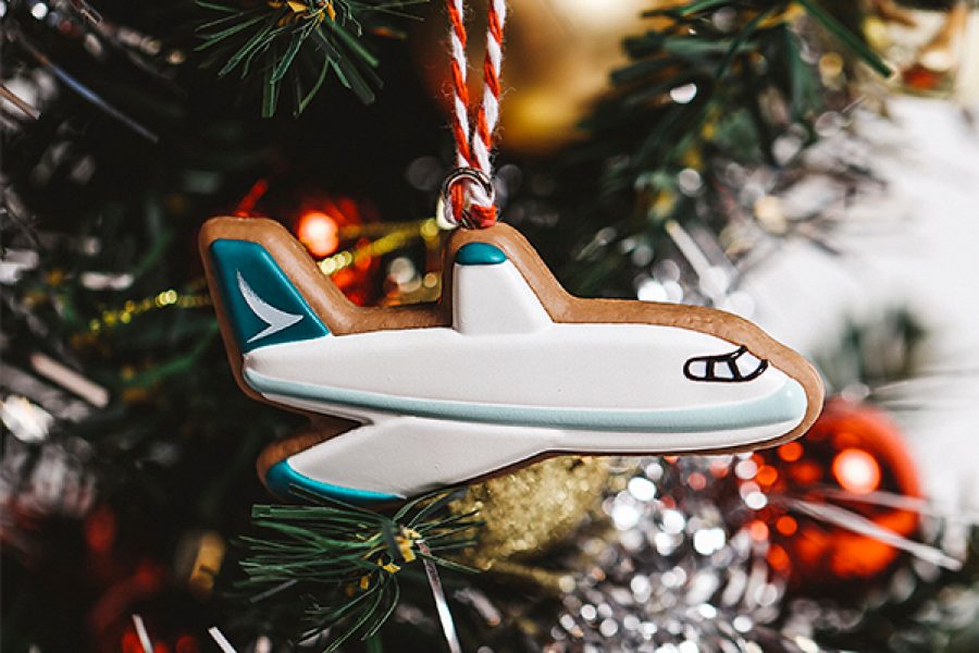 A close up of Cathay's DIY christmas gingerbread-themed ornament, featuring a Cathay Pacific aircraft with signature brushwing hanging on a Christmas tree