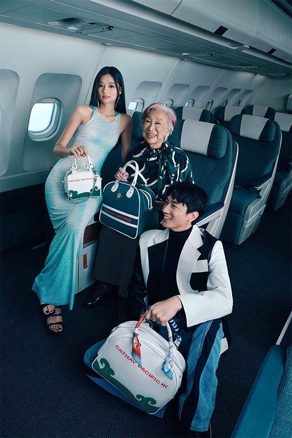 Kayan9896, Rebecca Pan and Terrance Lau sitting together inside an aircraft with Cathay Classic bowling bags in cream white and dark green 