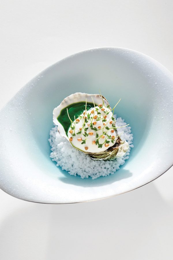 A white bowl filled with rice and topped with a green garnish