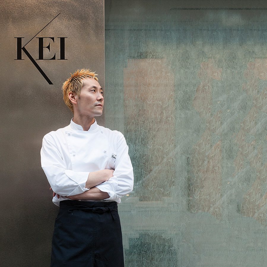 Chef Kei Kobayashi standing in front of Restaurant Kei with his arms crossed