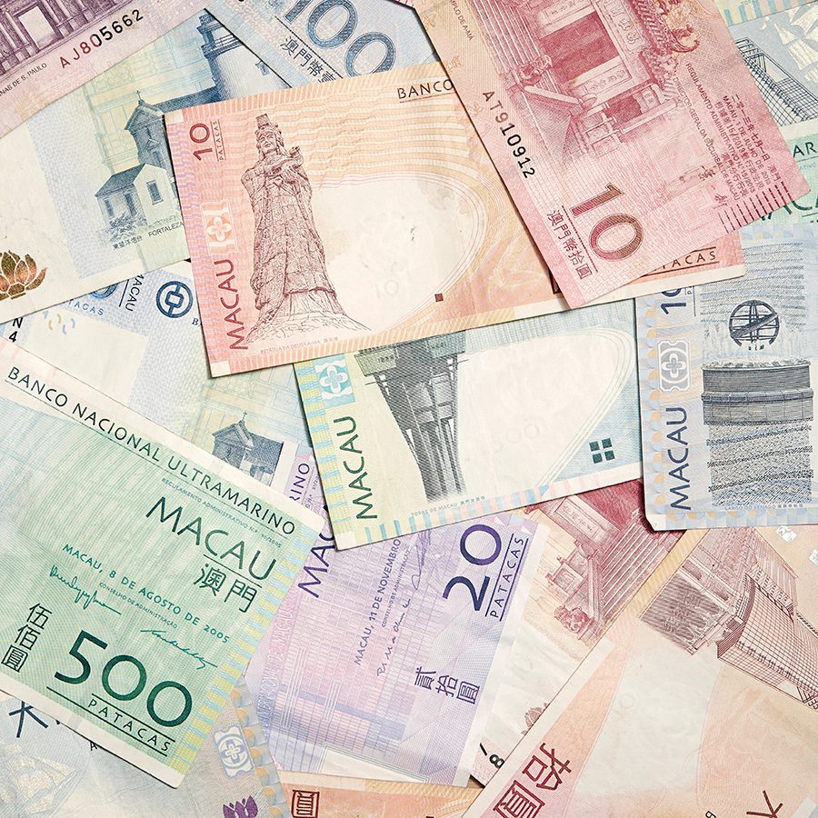 Macanese Pataca banknotes scattered across a surface