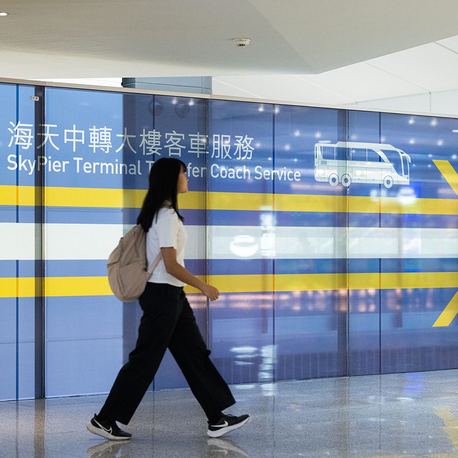 A passenger heading towards the SkyPier Terminal to take the transfer coach. 