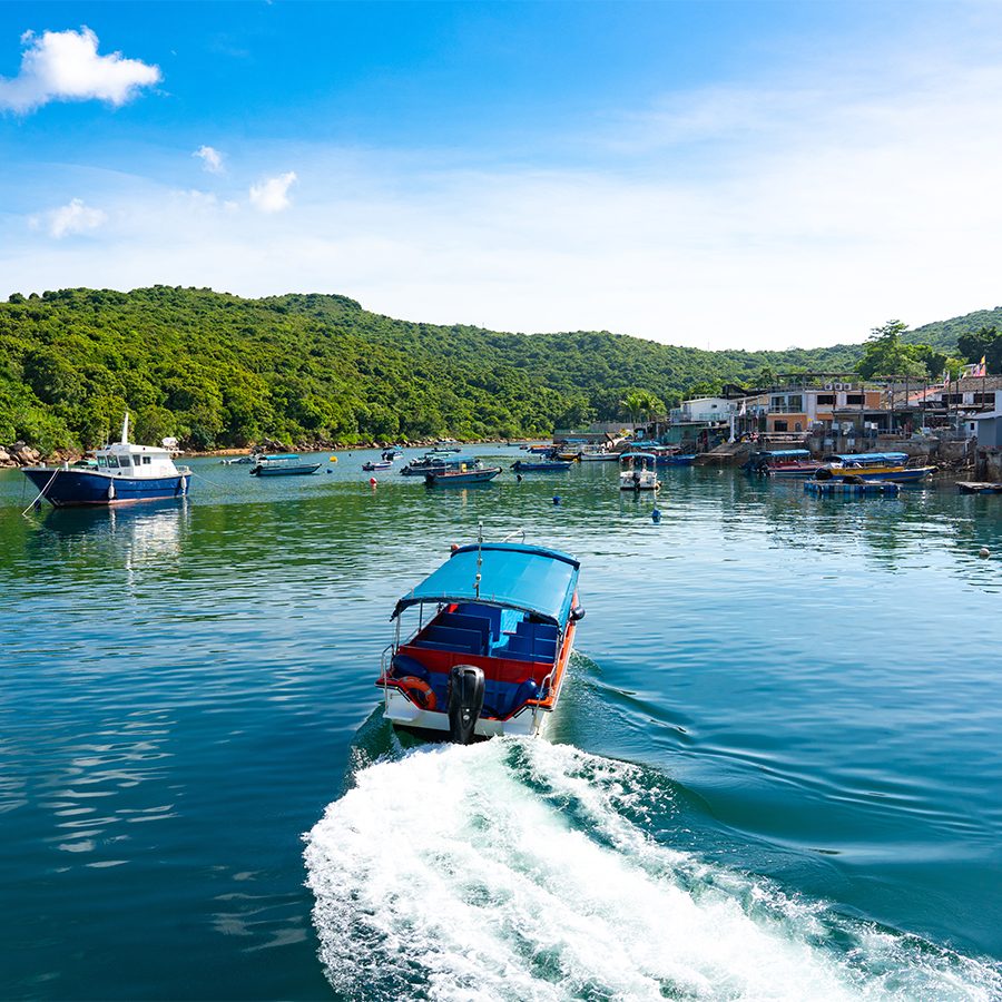  A blue sampan boat speeding across the water in Tap Mun island in a fishing village