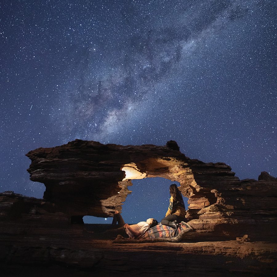 Women underneath stone at night, Western Australia