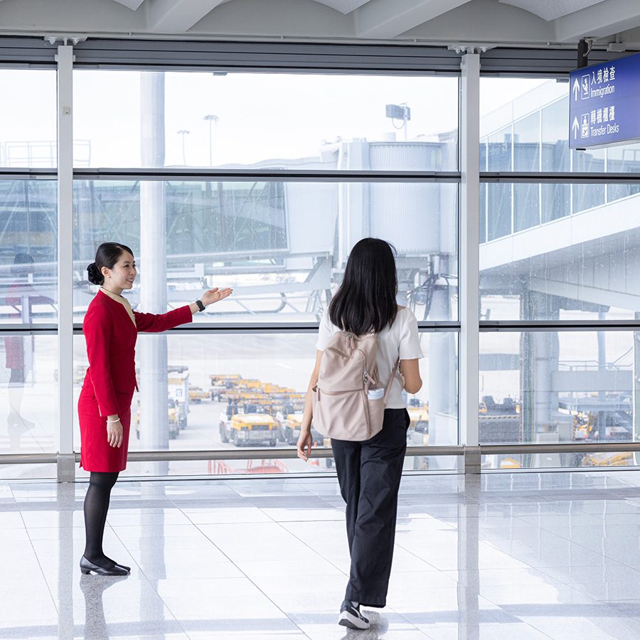 An airport staff welcomes a woman