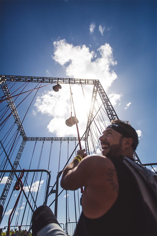 A man laughing while completing an obstacle course during a Spartan race