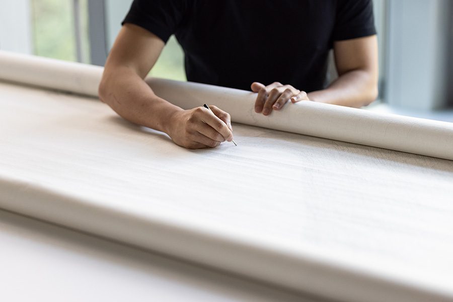 Artist Wai Pong Yu moves his pen across a huge sheet of paper