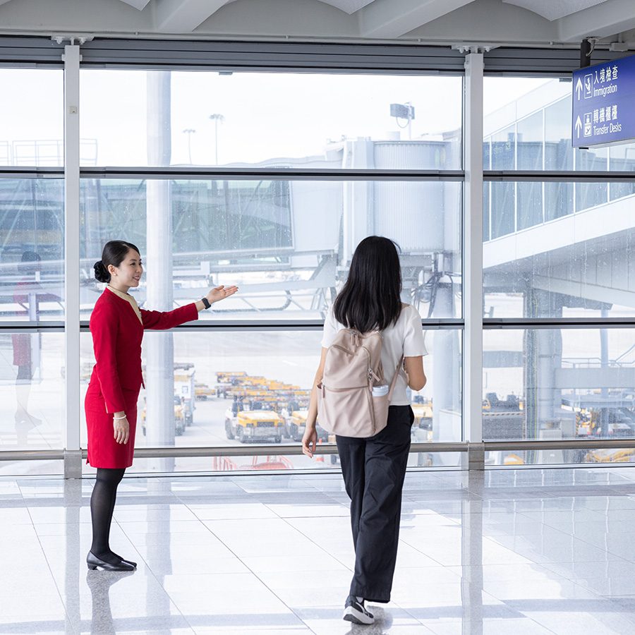 An airport staff welcomes a woman