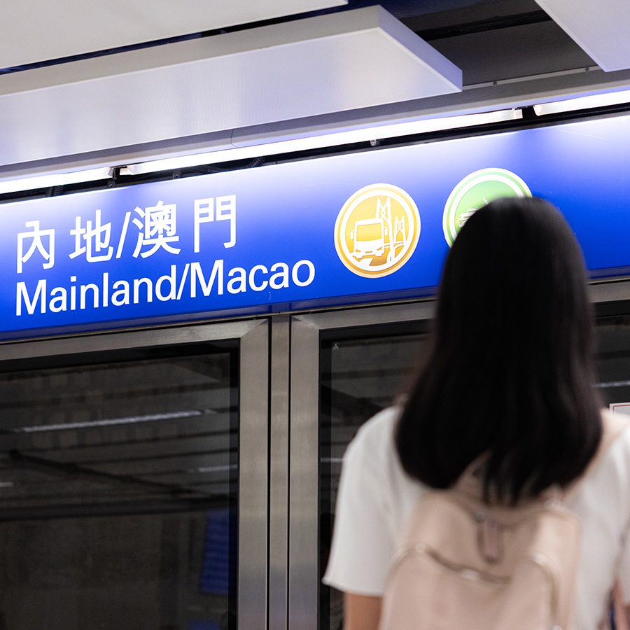 Woman looking at the sign for Mainland/Macao in HKIA