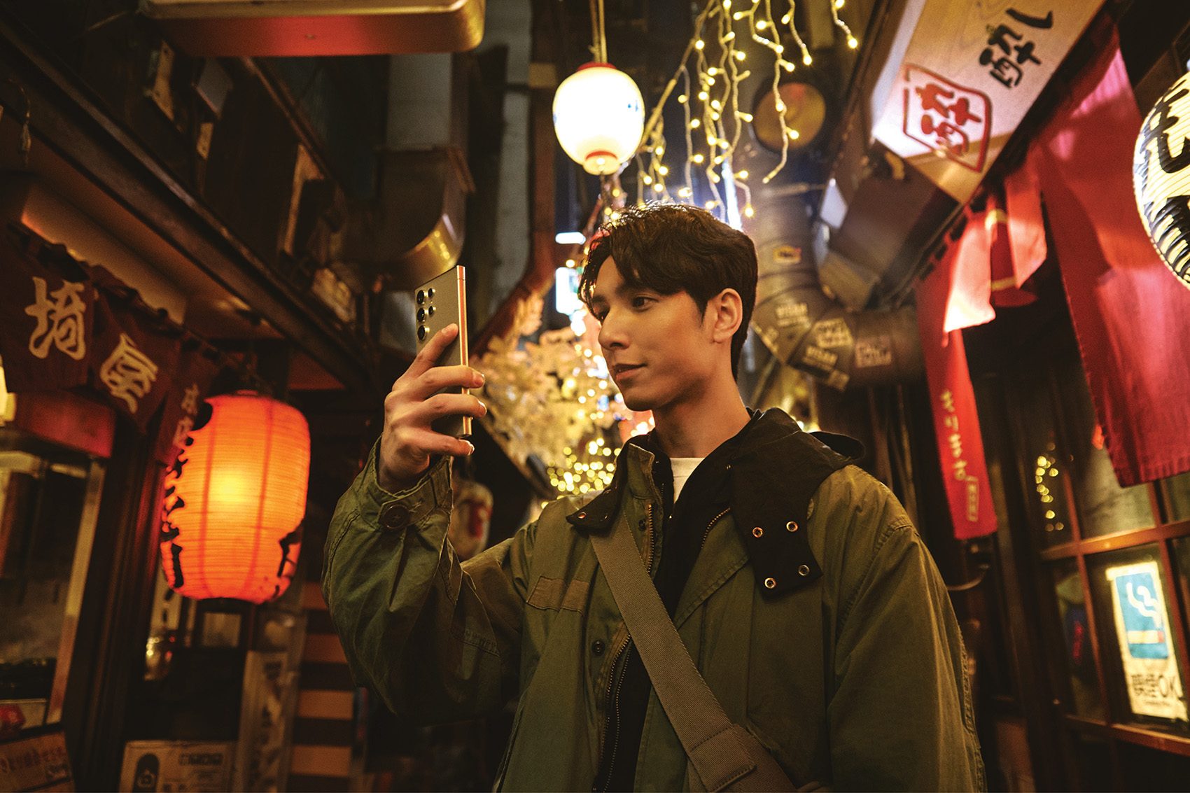 In partnership with Samsung. Man taking photo on phone in Tokyo.