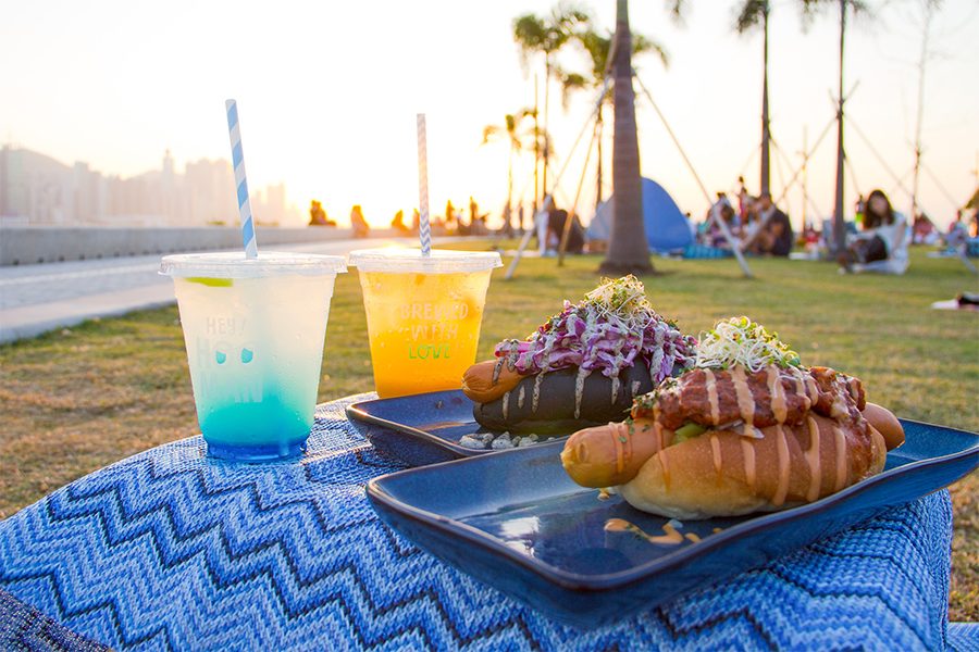 Hooman by the Sea drinks and hotdogs with victoria harbour in background