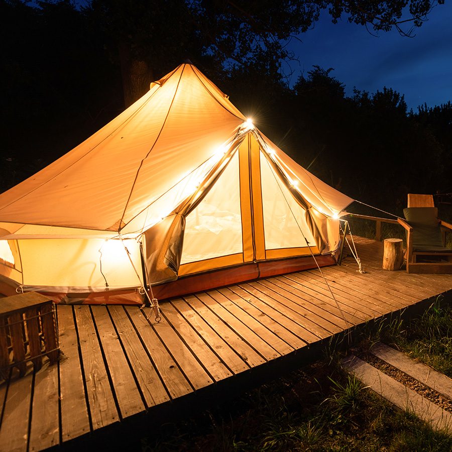 Glamping tent lit up at night