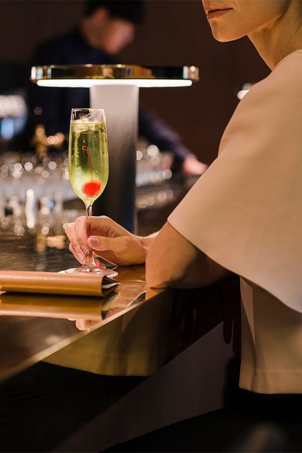 Person holding glass in bar