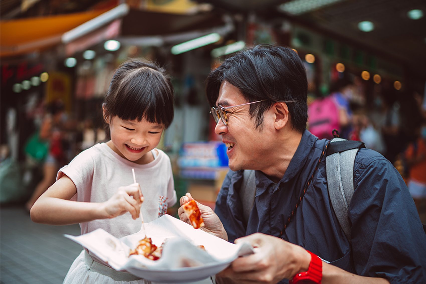 Man and child eating street food