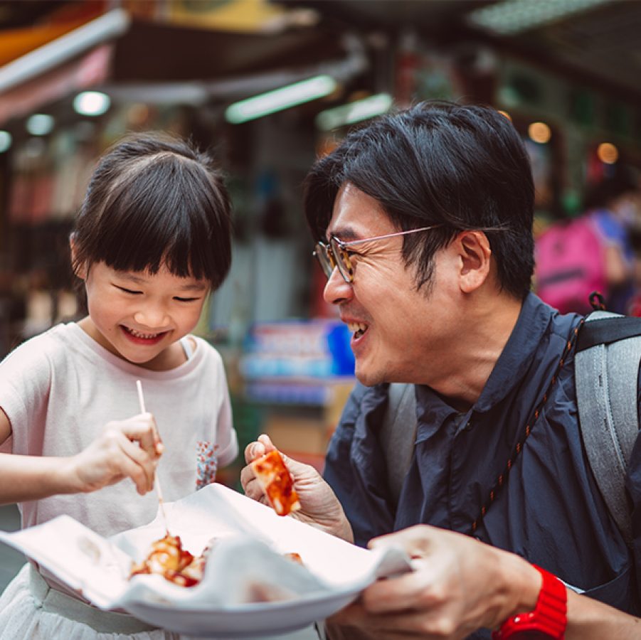 Man and child eating street food