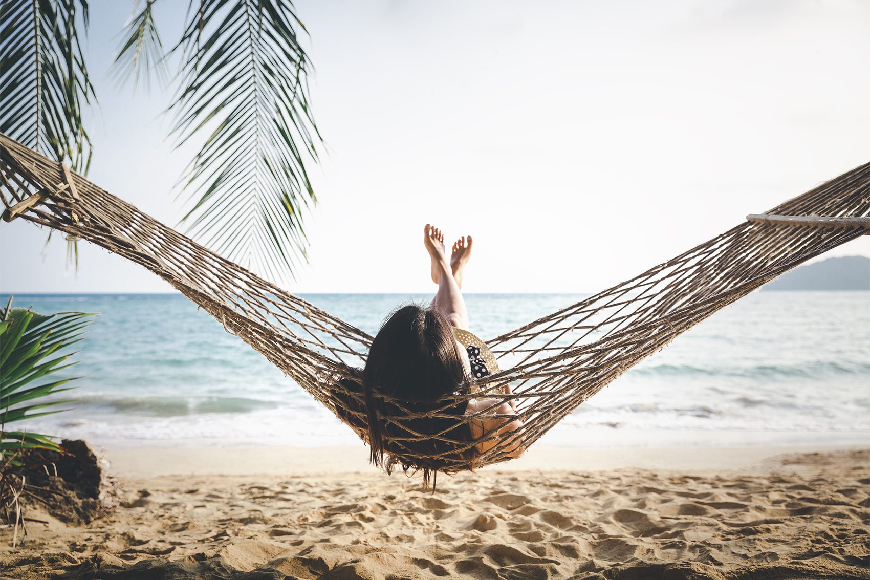 Woman relaxing in a hammock on a beach