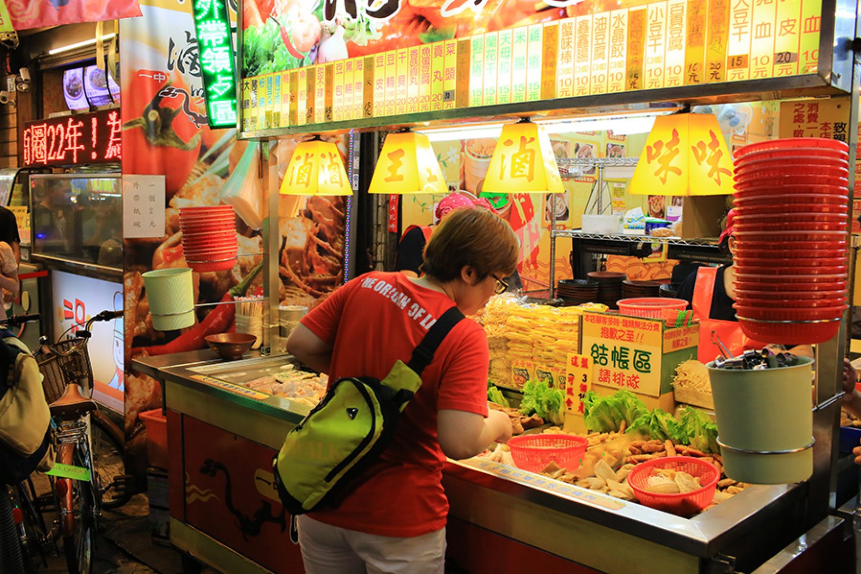 Woman browsing a food stall on Yizhong Street, Taichung