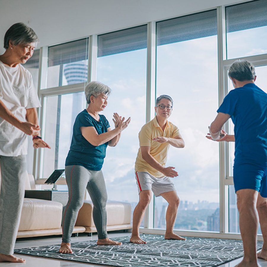 A man teaching his elderly friends tai chi