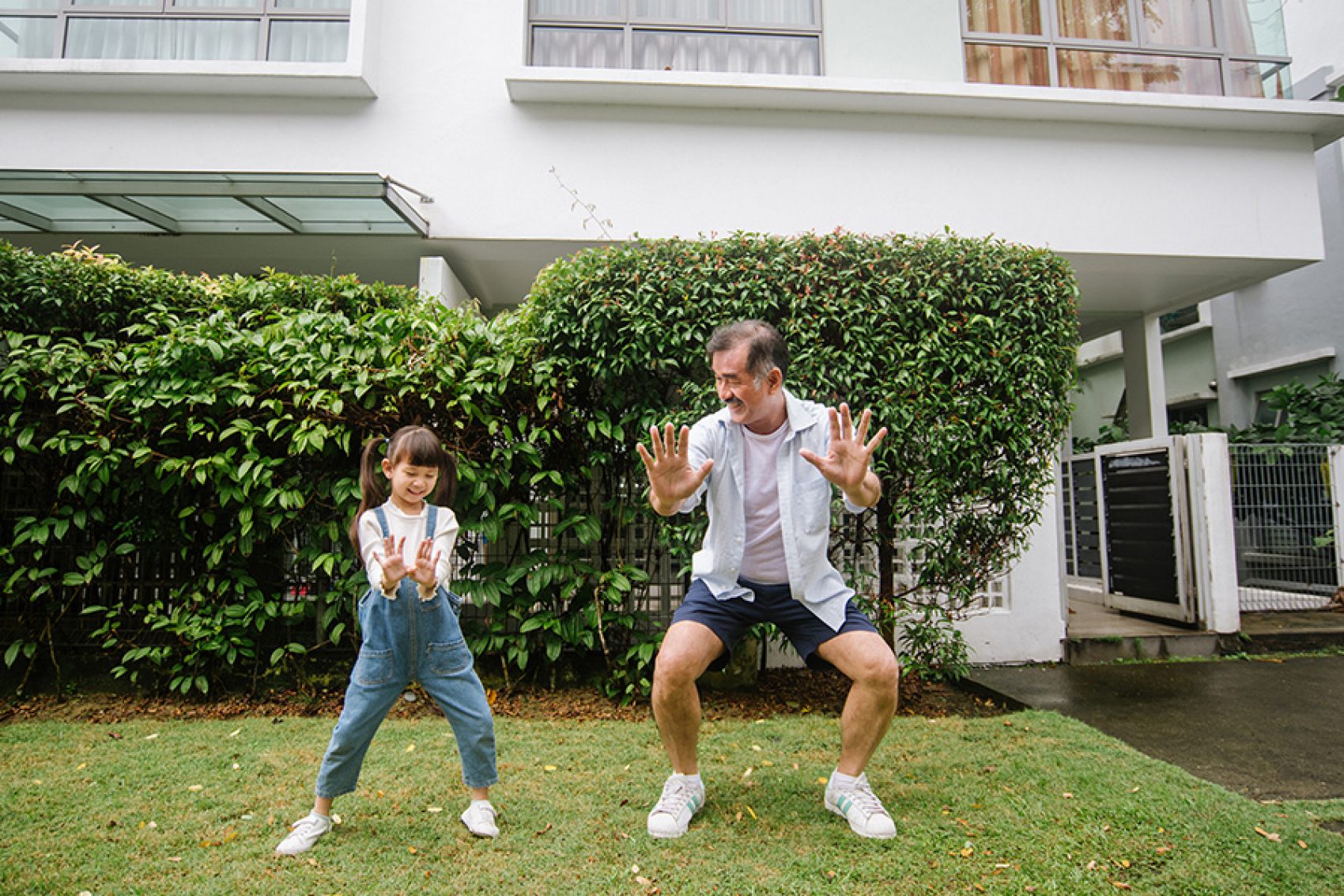 A man and his granddaughter doing tai chi