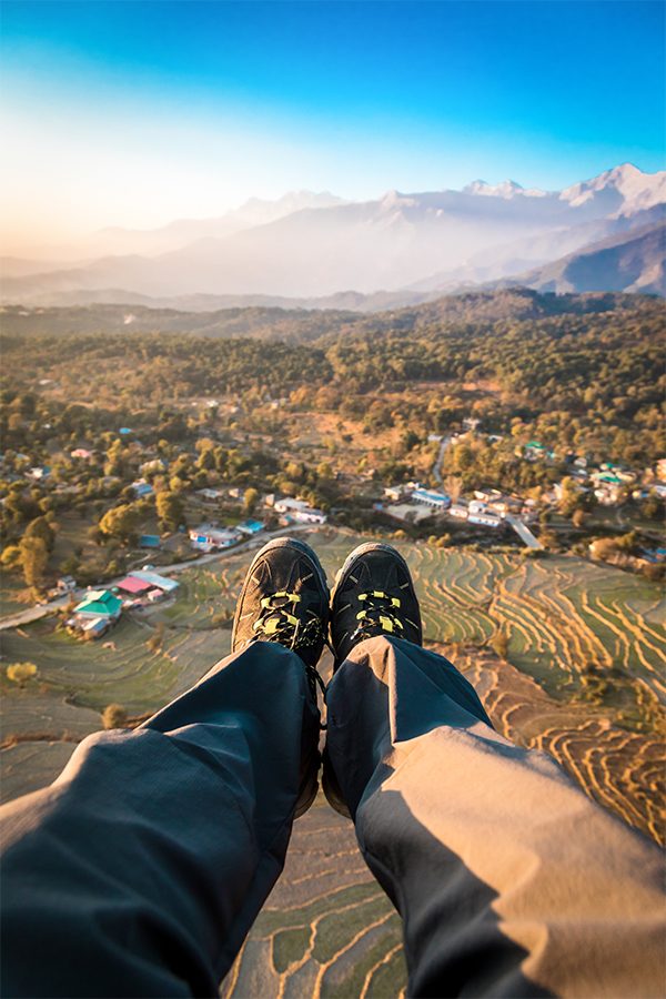 Dhauladhar range with a paraglider's legs in the frame