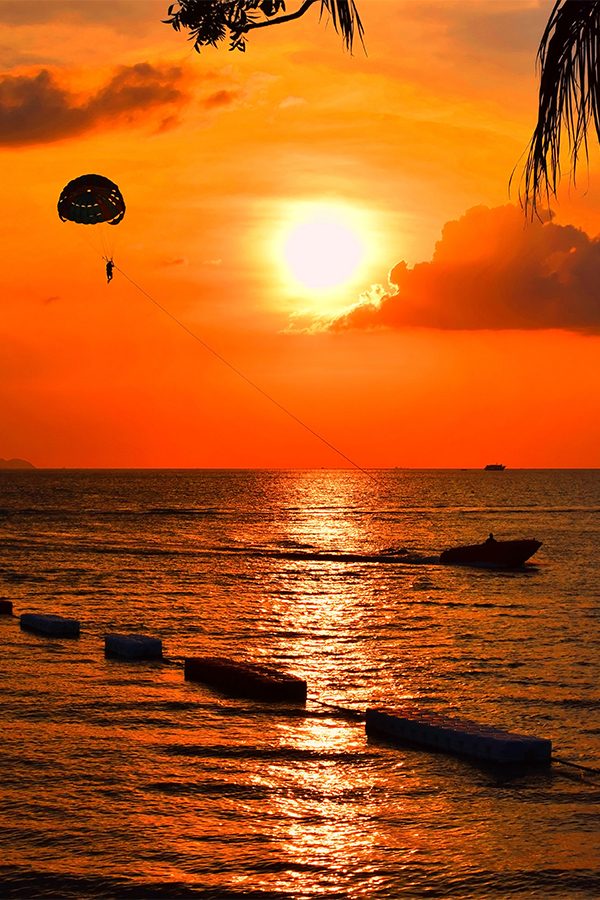 Parachuting into the sunset above water