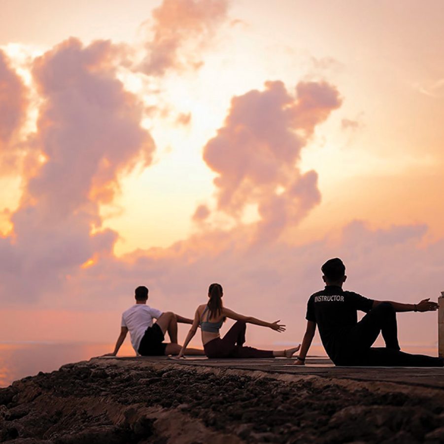 People doing yoga at sunset in Bali