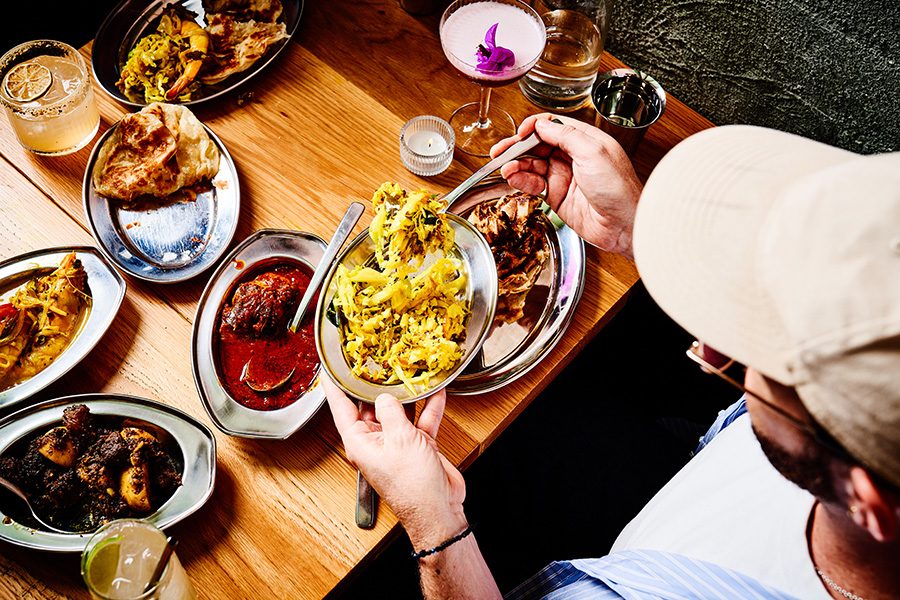 A man eating from a table full of food in Toddy Shop, Fitzroy
