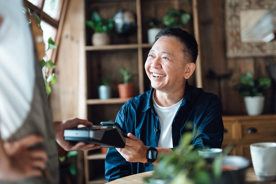 Man paying for the bill at a café with contactless payment