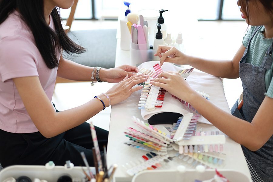 A woman getting a manicure choosing a colour for her nails at the nail salon