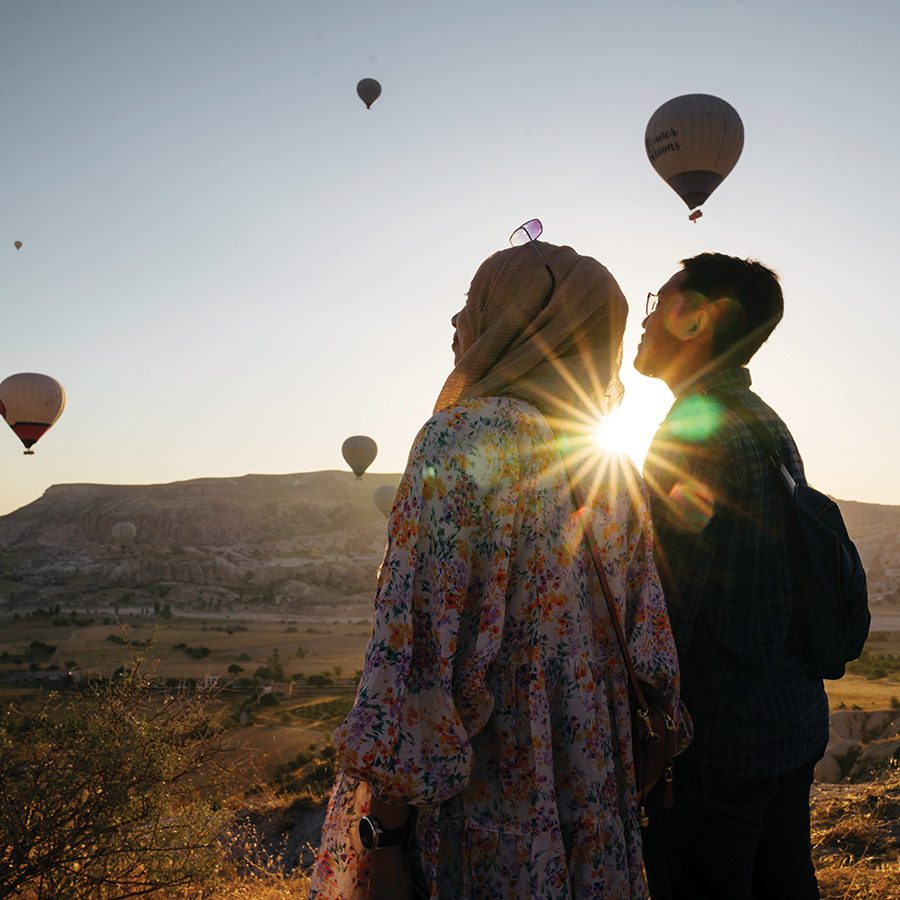 A couple watching hot air balloons
