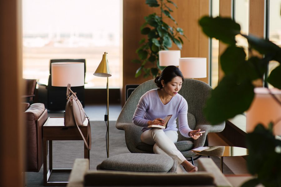 A woman looking on her phone while relaxing in a lounge