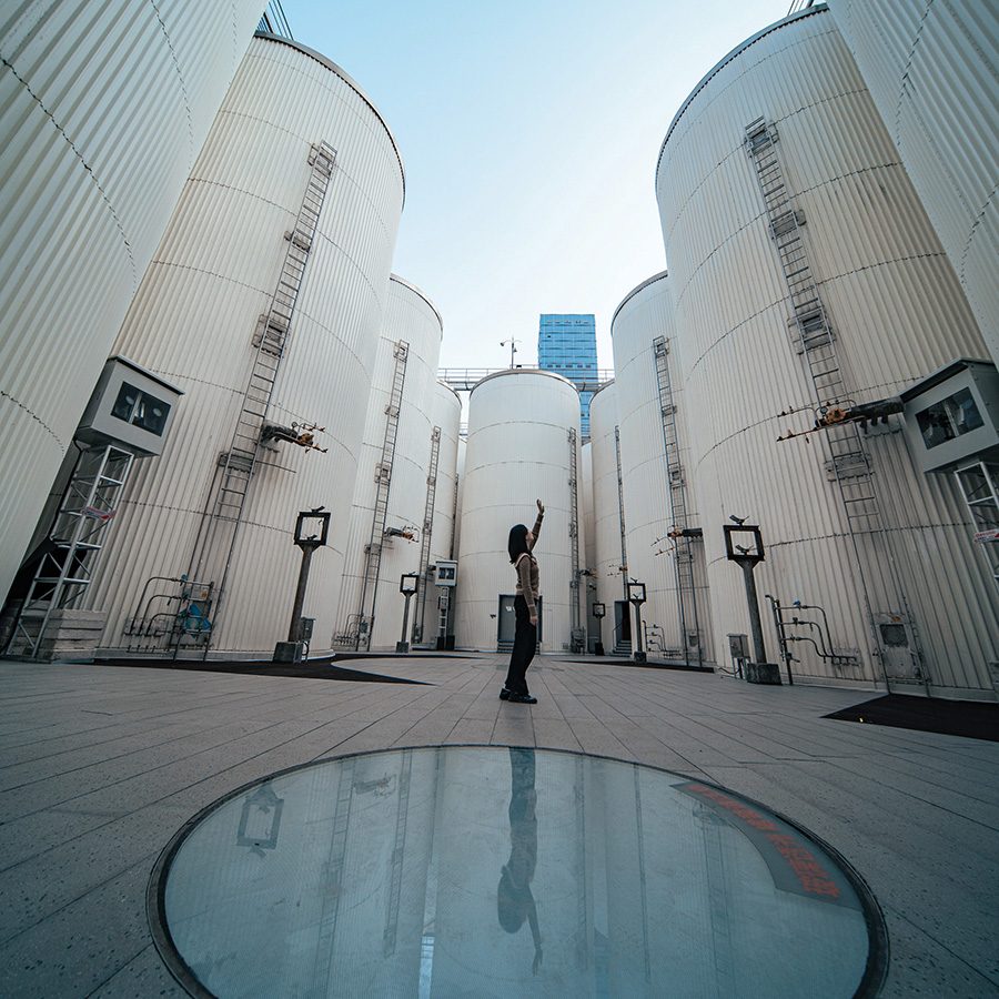 Woman standing under Fermentation Silos 