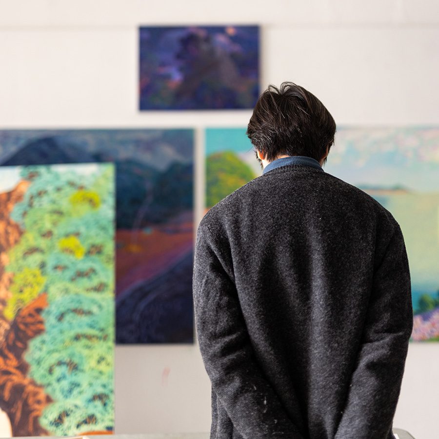 Artist stephen wong looking at artwork in his gallery