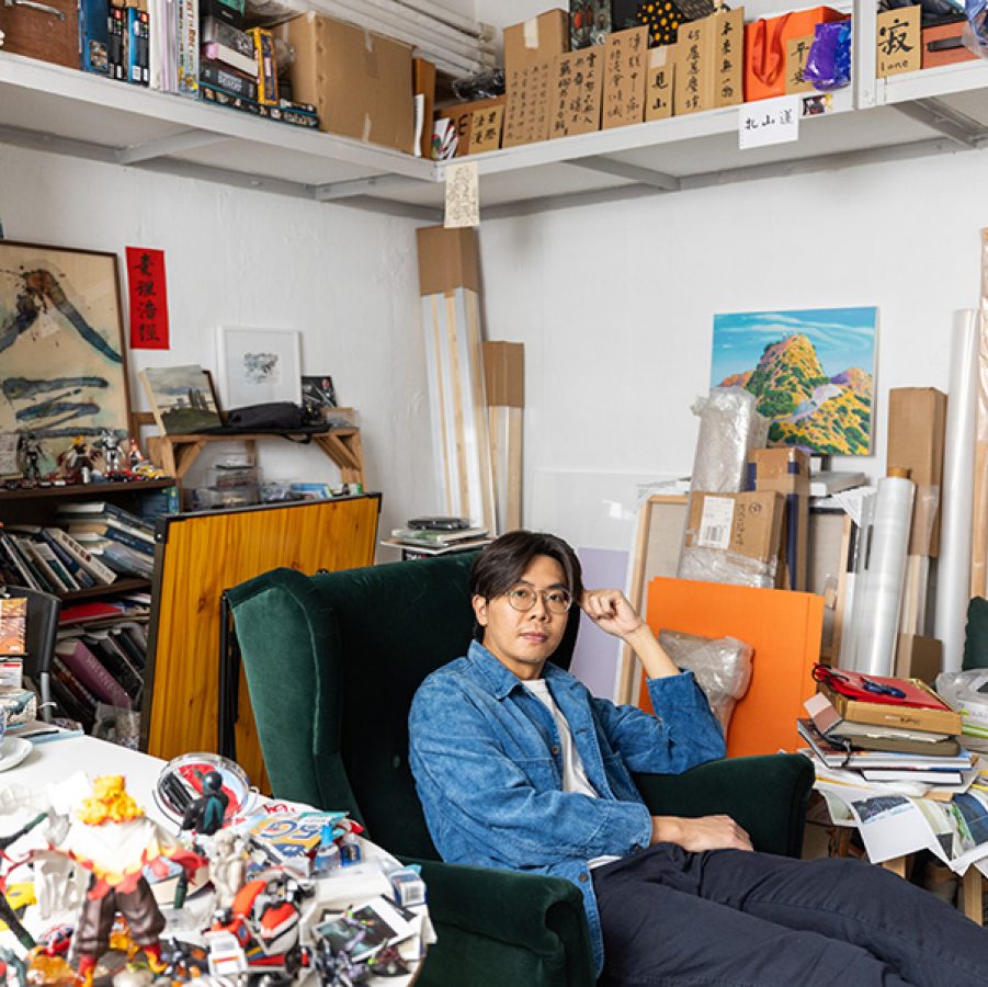Artist stephen wong sitting in his studio surrounded by artworks