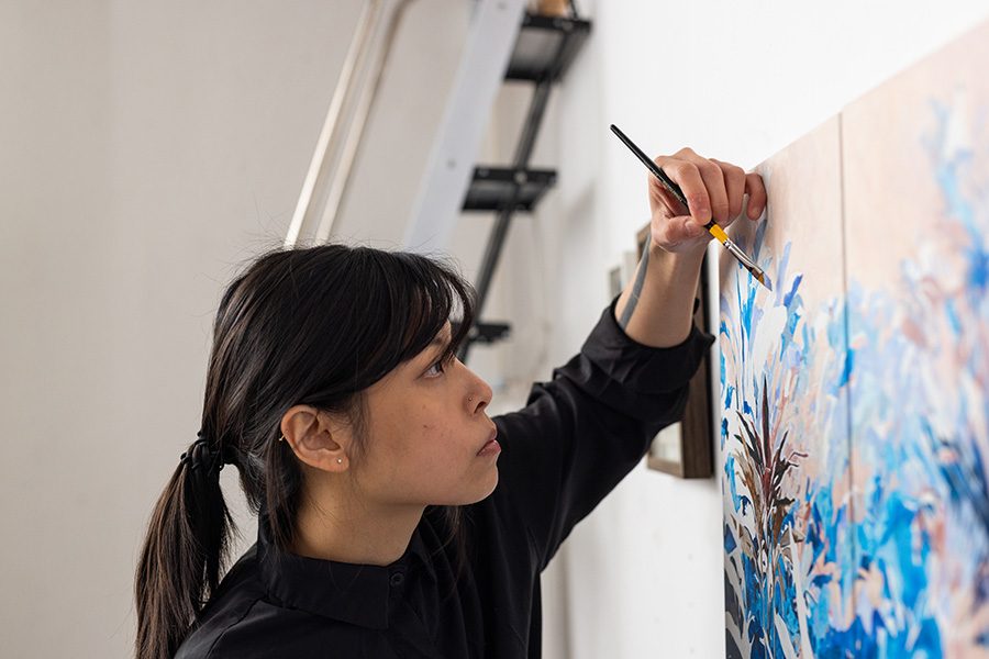 artist Tobe Kan painting in her art studio