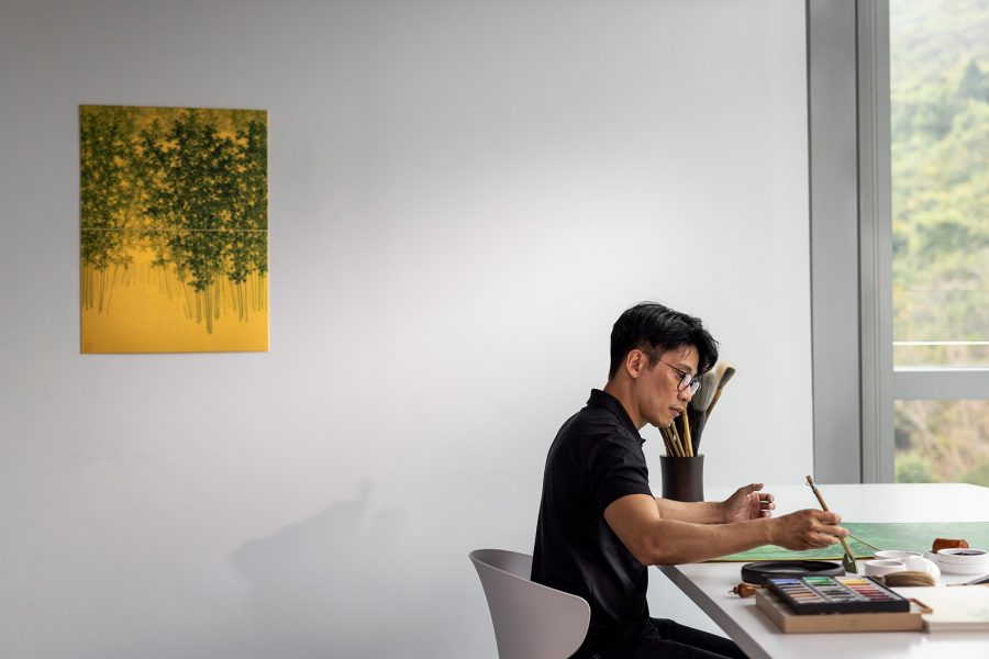 Ink artist Koon Wai Bong sits at his desk and works.