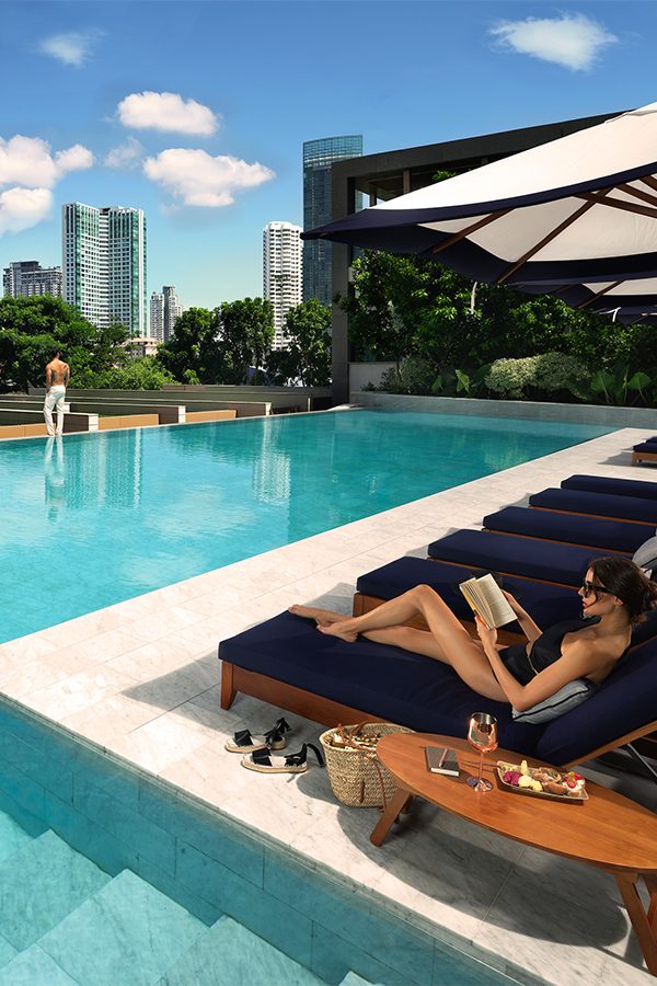 A woman reads a book on a lounge chair by the Swimming Pool in Capella.
