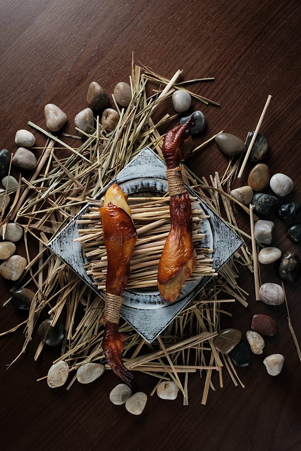 AREA presents two legs of cured meat on decorative sticks and stones for a rustic style