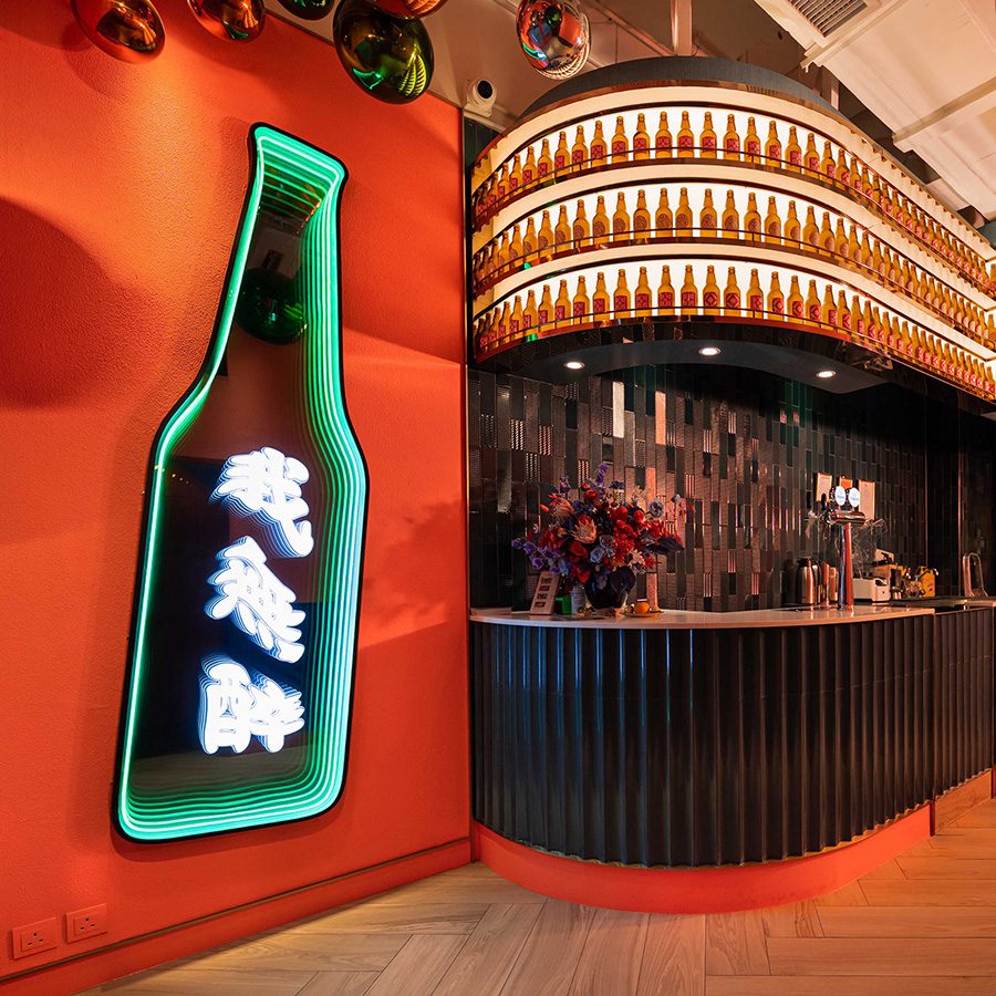 Bino N Booze vibrant decor and beer bottle light box next to the bar counter